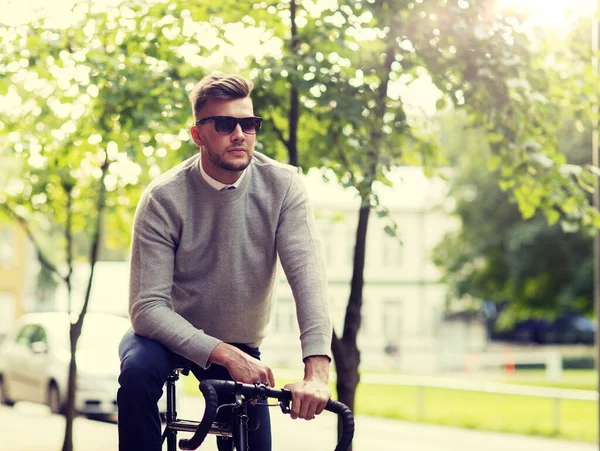 거리 시에 자전거를 타고 그늘에 있는 젊은이 — 스톡 사진
