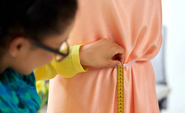 Fashion designer measuring dress with tape measure — Stock Photo, Image