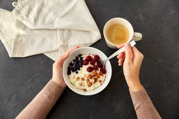 Hands with porridge breakfast and cup of coffee — Stock Photo, Image