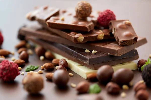 Zblízka různé čokolády, bonbóny a ořechy — Stock fotografie