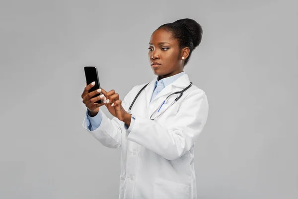 Medico afroamericano femminile con smartphone — Foto Stock