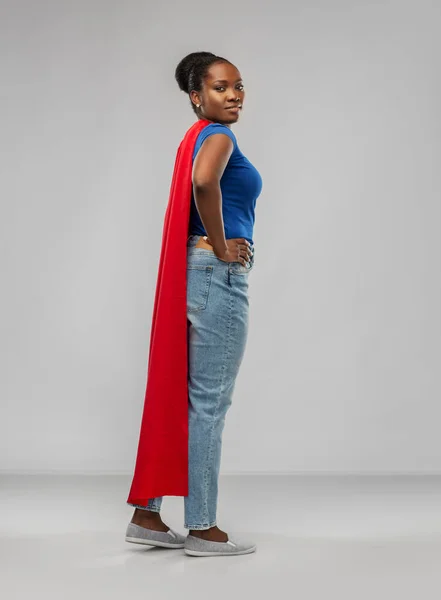 African american woman in red superhero cape — Stockfoto