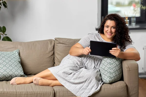 Kvinna med surfplatta dator på soffa hemma — Stockfoto