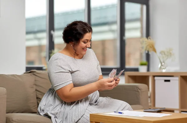 Woman with money, papers and calculator at home — Stock Photo, Image