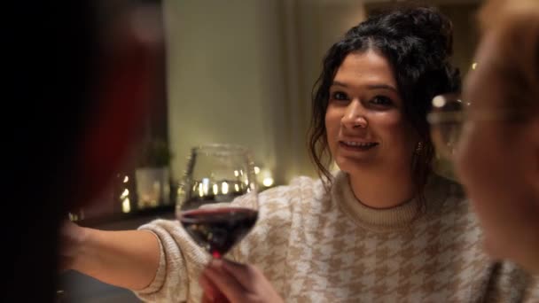 Glada vänner dricker rött vin på julfesten — Stockvideo