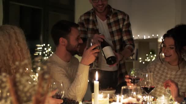 Счастливые друзья с красным вином на рождественской вечеринке — стоковое видео