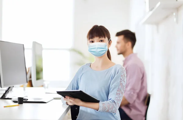 Asiatin in medizinischer Schutzmaske im Büro — Stockfoto