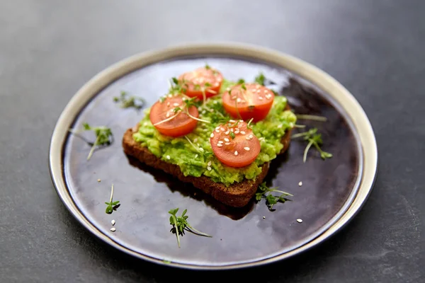 Pane tostato con purè di avocado e pomodoro ciliegia — Foto Stock