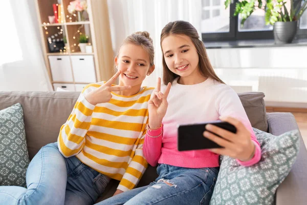 Meninas felizes levando selfie com smartphone em casa — Fotografia de Stock