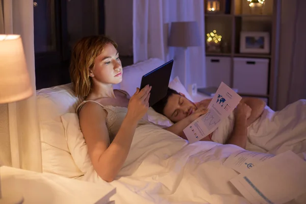 Mujer con Tablet PC trabajando en la cama por la noche —  Fotos de Stock