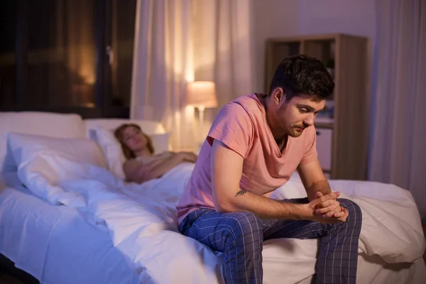 Сумний чоловік з безсонням сидить на ліжку вночі — стокове фото