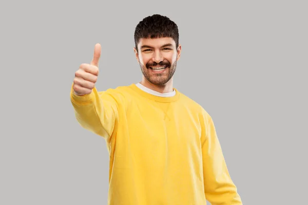 Sorrindo jovem mostrando polegares para cima — Fotografia de Stock