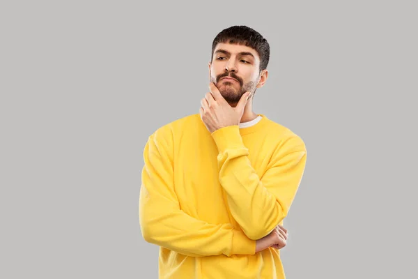 Hombre joven pensando en sudadera amarilla —  Fotos de Stock