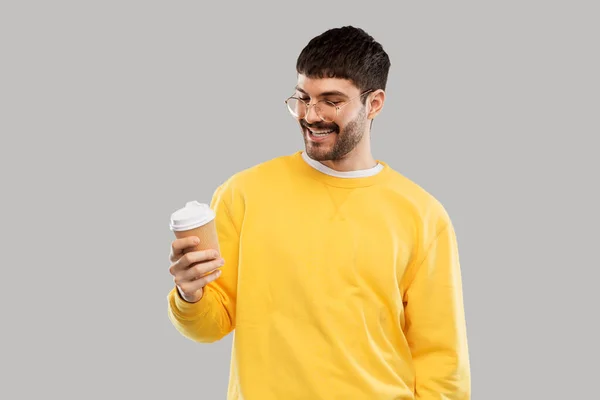 Smiling young man with takeaway coffee cup — Stockfoto