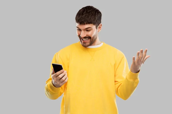 Glad leende ung man med smartphone — Stockfoto