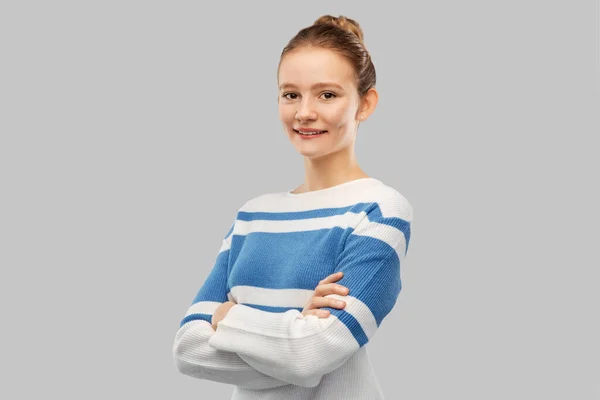 Smiling teenage girl with crossed arms in pullover — Stock fotografie