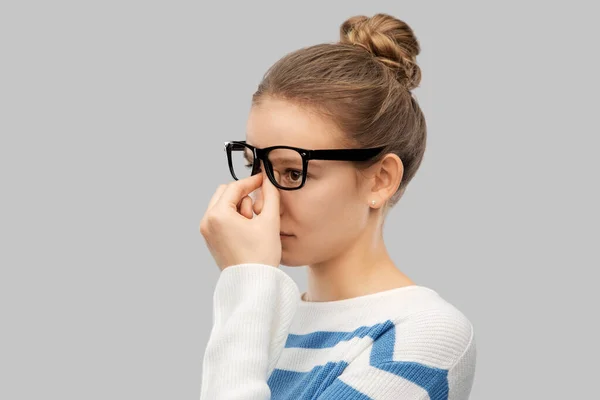 Teenage girl in glasses rubbing nose bridge — Φωτογραφία Αρχείου