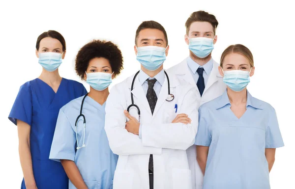 Médicos y enfermeras con máscaras médicas protectoras — Foto de Stock