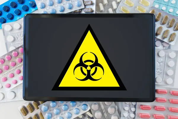 Signo de precaución boihazard, tableta PC y medicamentos — Foto de Stock