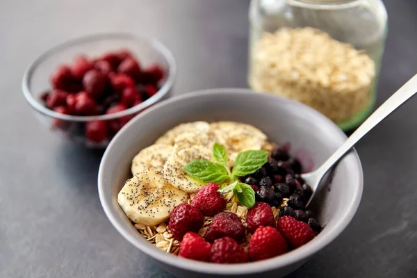 Desayuno de cereales con bayas, plátano y cuchara —  Fotos de Stock