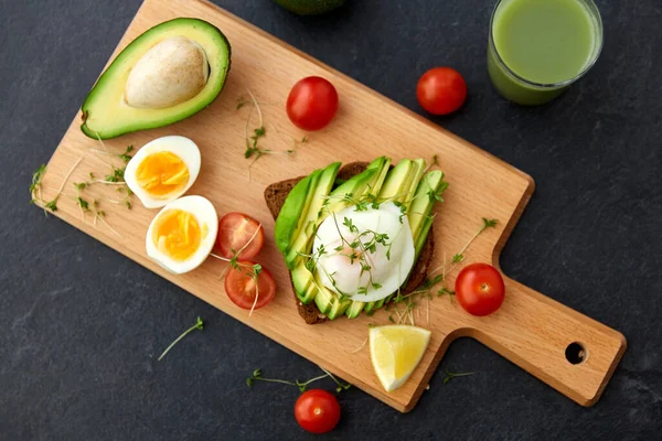 Pan tostado con aguacate, huevos y tomates cherry — Foto de Stock