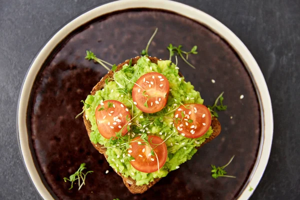 Pane tostato con purè di avocado e pomodoro ciliegia — Foto Stock