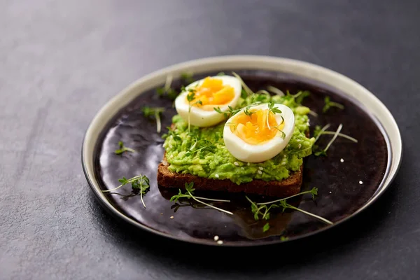 Toast bread with mashed avocado and eggs — Stockfoto