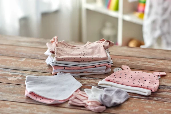 Ropa de bebé en la mesa de madera en casa —  Fotos de Stock