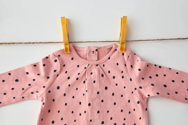 Camisa rosa para niña colgando de una cuerda con alfileres — Foto de Stock