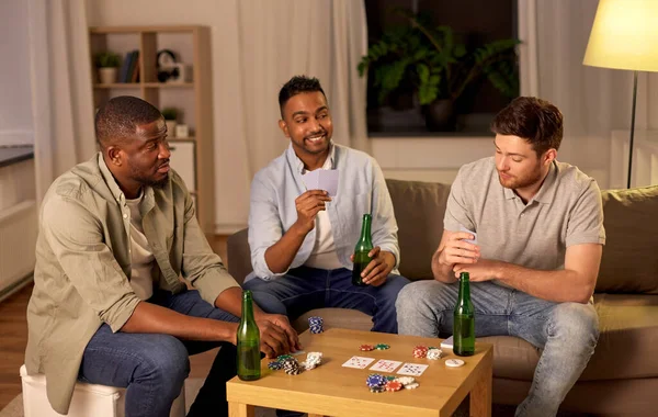 Souriant amis masculins jouer aux cartes à la maison — Photo