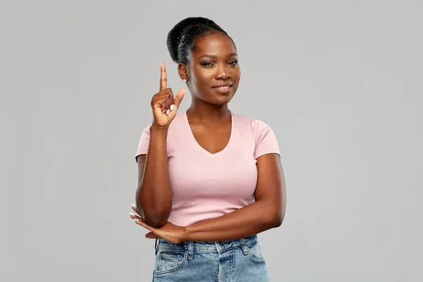 Glückliche afrikanisch-amerikanische Frau zeigt mit dem Finger nach oben — Stockfoto