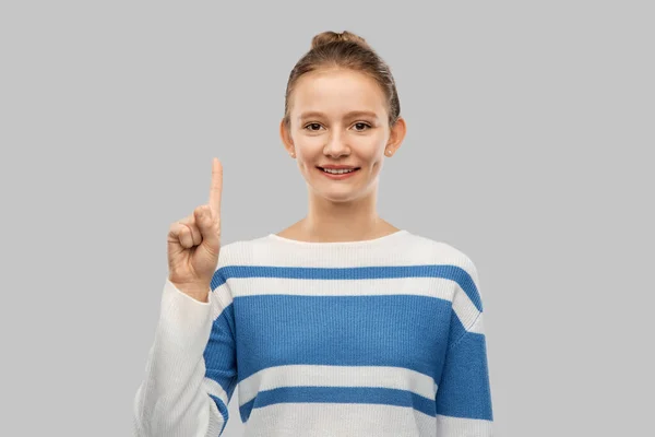 Feliz adolescente chica en suéter apuntando dedo hacia arriba — Foto de Stock