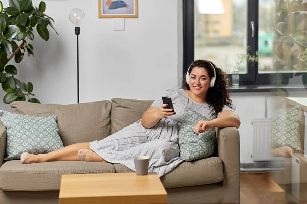 Mujer en auriculares escucha música en el teléfono inteligente —  Fotos de Stock