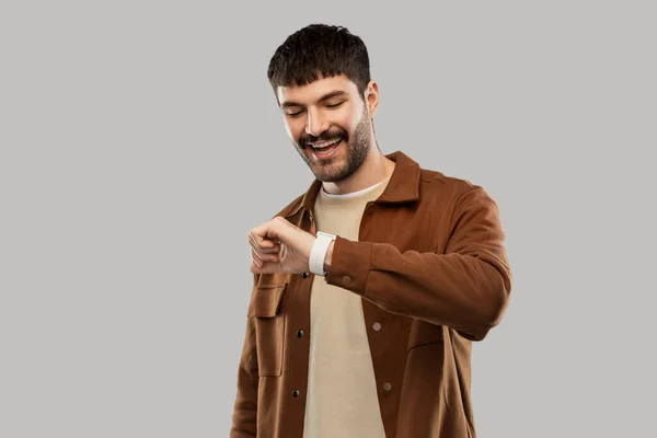 Jovem sorridente com relógio inteligente — Fotografia de Stock