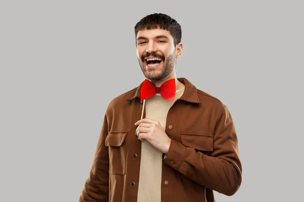 Uomo sorridente con papillon rosso partito accessorio — Foto Stock