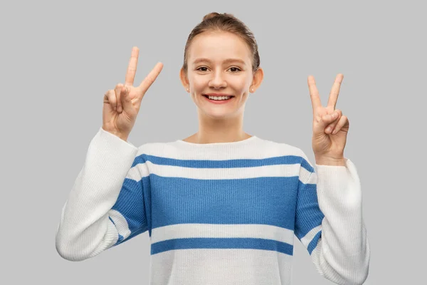 Smiling teenage girl showing peace hand sign — Stock Photo, Image