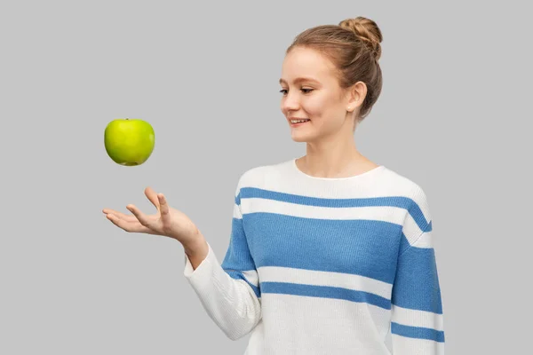 Smiling teenage girl in pullover with green apple — 图库照片