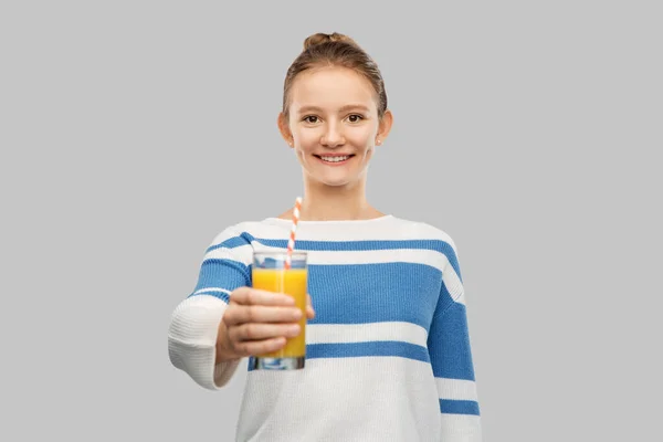 Sorridente ragazza adolescente in possesso di un bicchiere di succo d'arancia — Foto Stock