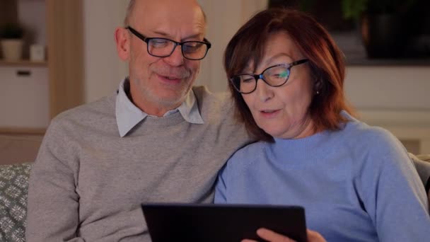 Happy senior couple with tablet pc at home — Stock Video