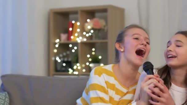 Evde mikrofonlu genç kızlar şarkı söylüyor. — Stok video
