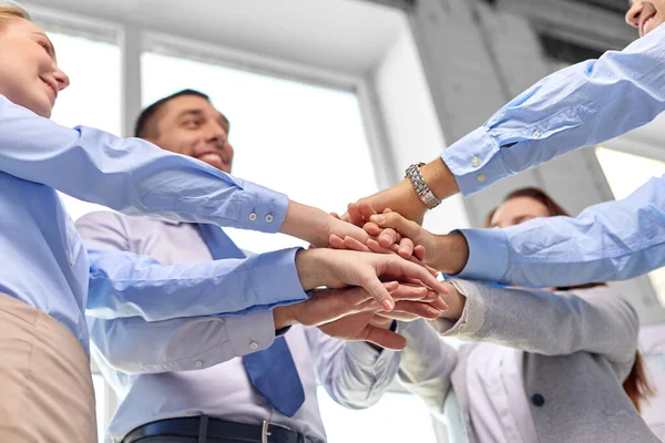 Közeli üzleti csapat egymásra kezét az irodában — Stock Fotó