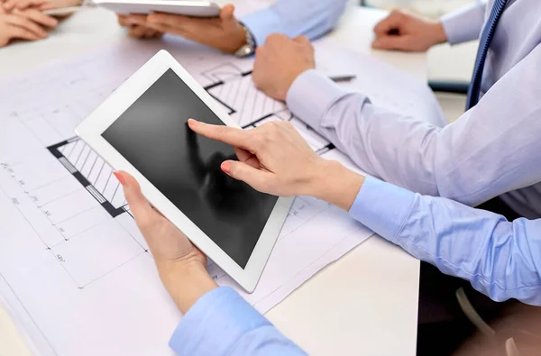 Arquitectos con tablet pc y plano en la oficina — Foto de Stock