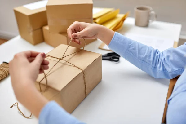 Frau packt Paket und bindet Seil bei Post — Stockfoto