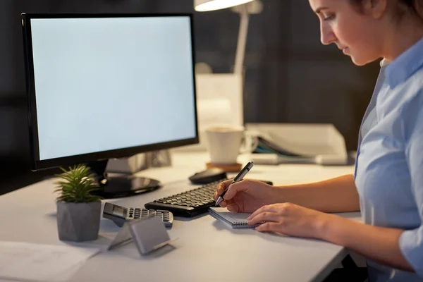 Femeie de afaceri care scrie pe notebook la birou de noapte — Fotografie, imagine de stoc