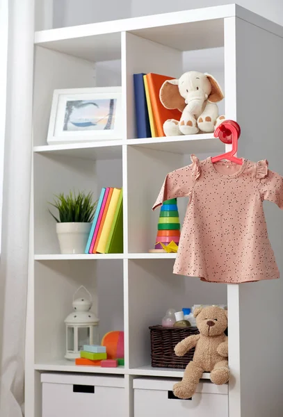 Interior de la habitación de los niños con librería y vestido de bebé — Foto de Stock