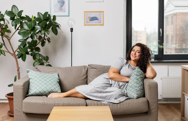 Heureuse jeune femme couchée sur le canapé à la maison — Photo