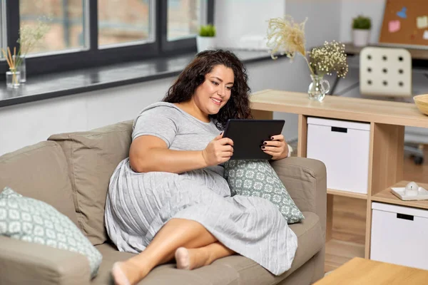 Frau mit Tablet-PC zu Hause auf Sofa — Stockfoto