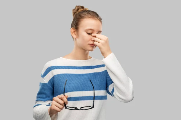 Tiener meisje met bril wrijven neus brug — Stockfoto