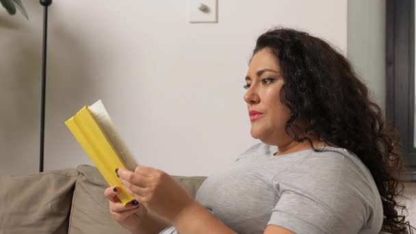 Mujer leyendo libro y bebiendo café en casa — Vídeo de stock