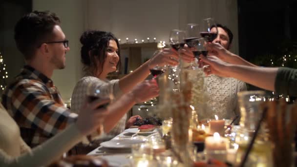 Gelukkig vrienden drinken rode wijn op kerstfeest — Stockvideo